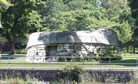 flagstone-built house with a tin boat as a roof